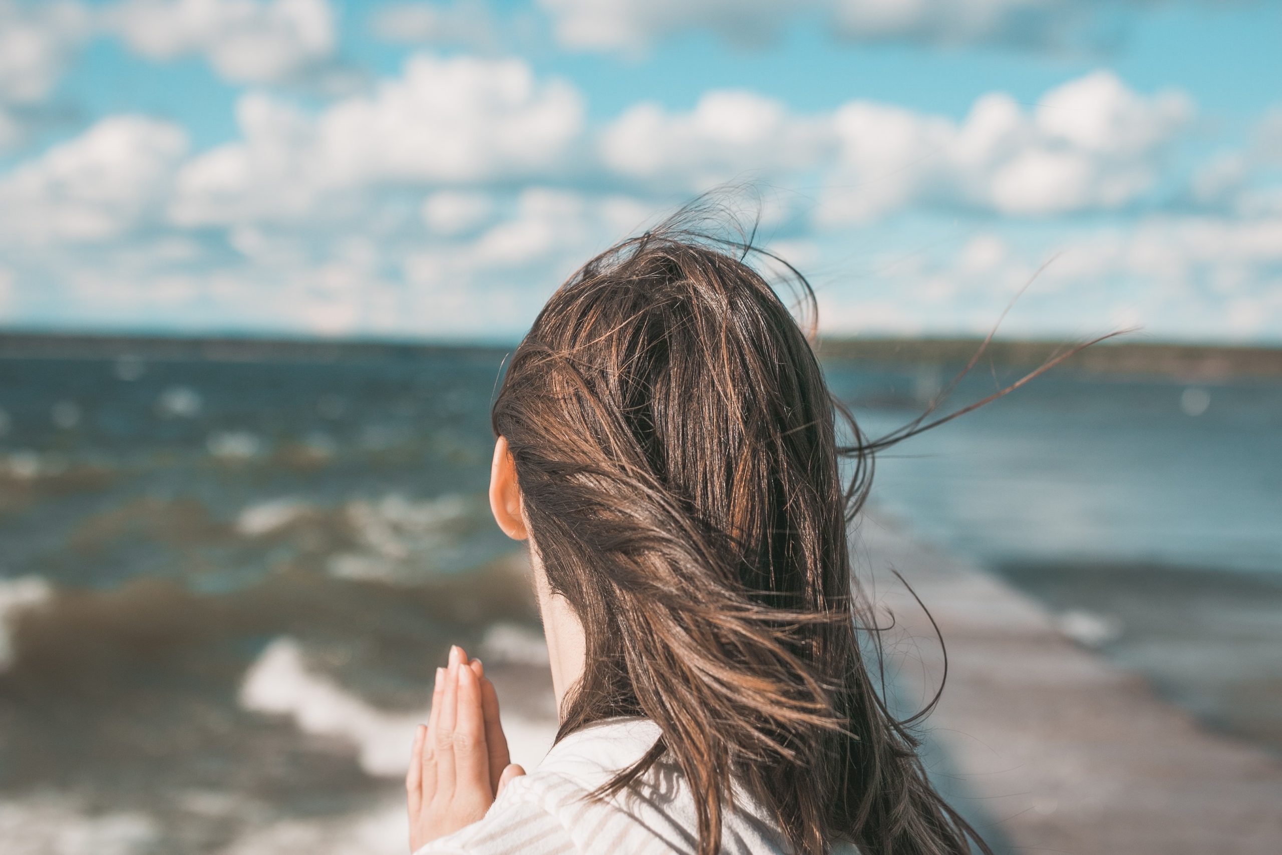 woman being grateful at beach